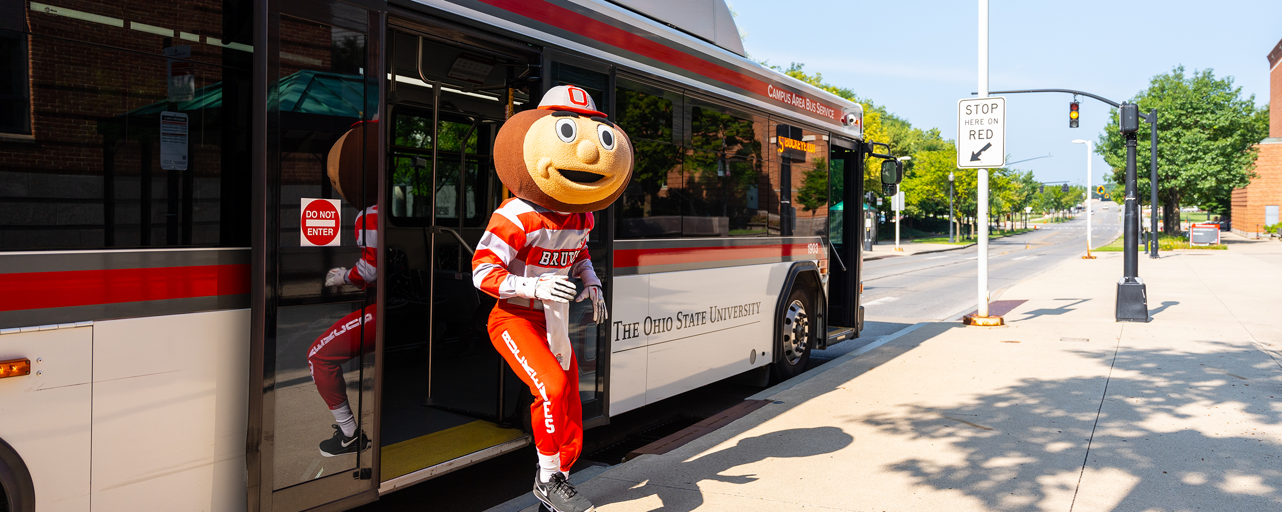 Photo of Brutus the Buckeye exiting a CABS bus.