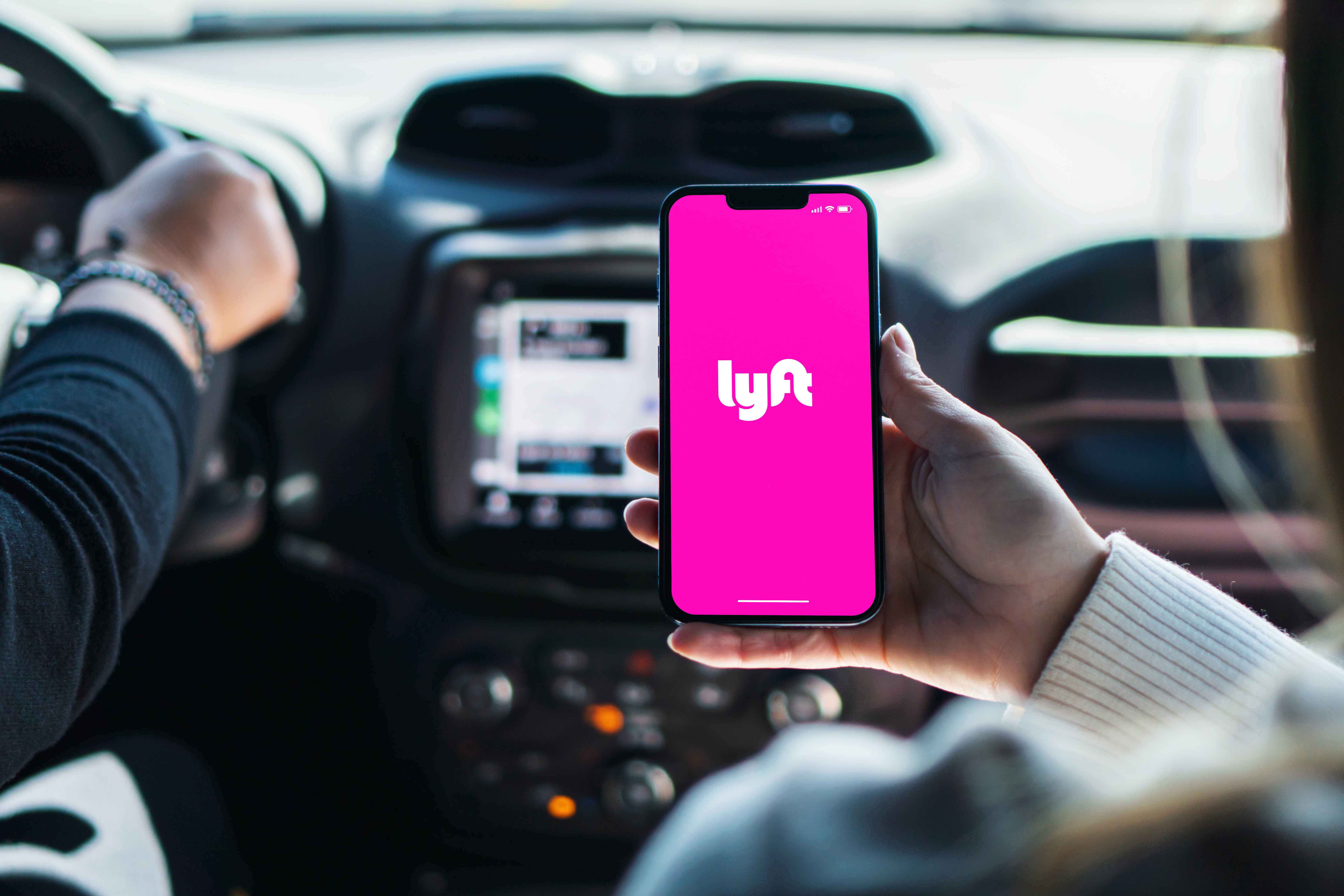 Lyft app loading on a phone inside a vehicle