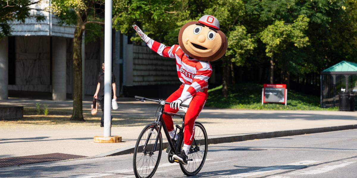 Brutus Buckeye riding a bicycle