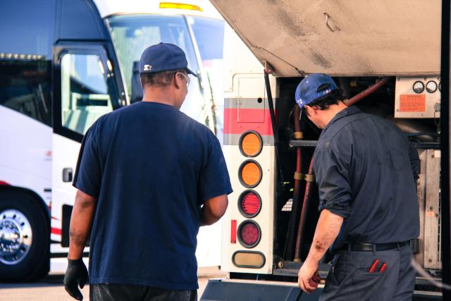 two mechanics looking at bus engine