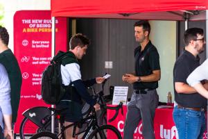 One student on a bicycle is seen chatting with a man standing next to him.